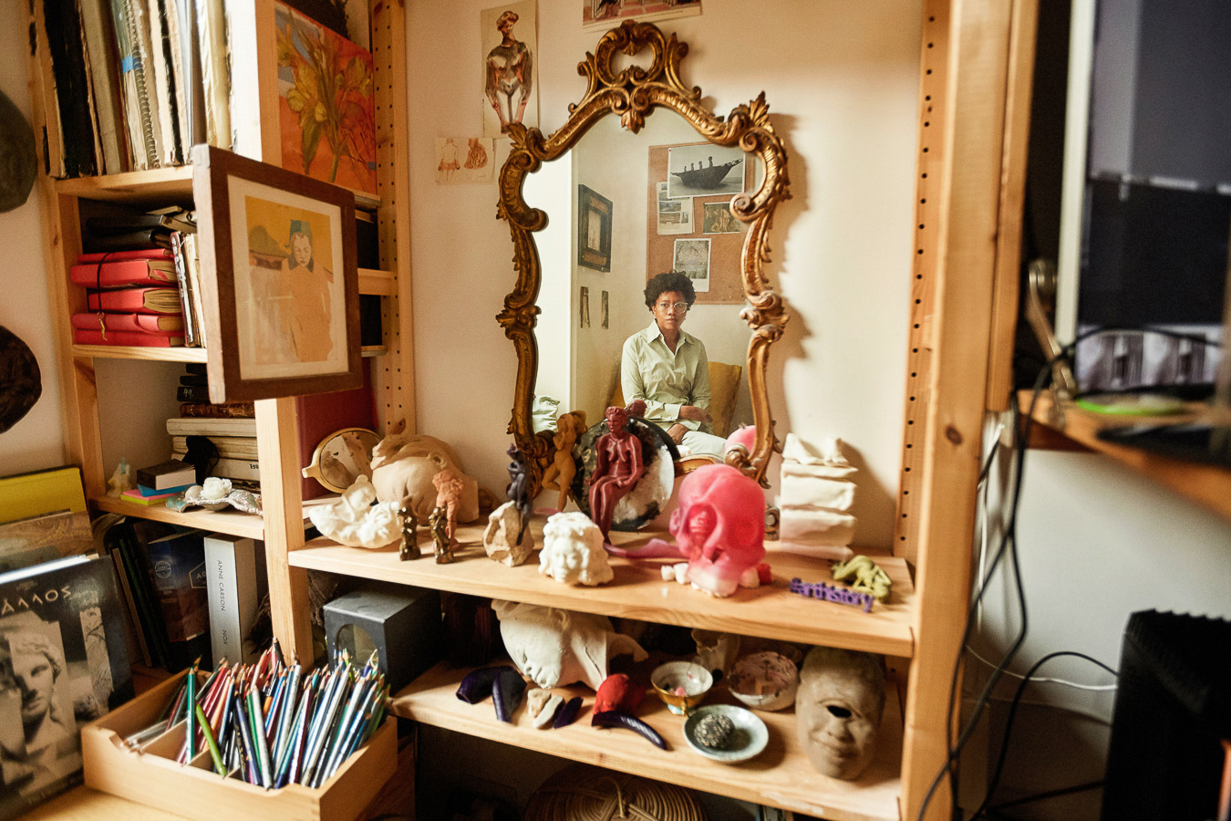 Auriea Harvey reflected in a gilded mirror, among sculptures, books and drawings in her studio in Rome